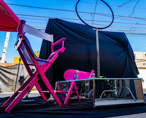low shot of All Star Stages Lyra X Spinner with mirrored silver chrome side kits and hot pink baseball bat skateboard and director chair